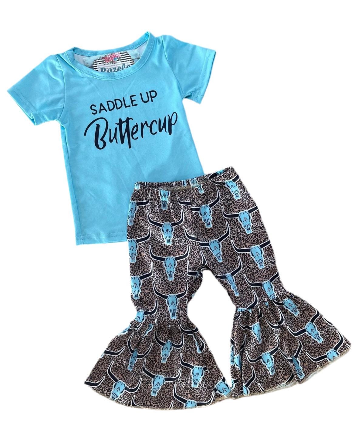 Saddle Up Buttercup! Girls Bell Bottom Outfit, Cowgirl Outfit, Turquoise T-Shirt & Cow Skull Cheetah Print Flares. Featuring a vibrant turquoise t-shirt and flared cow skull cheetah print bell bottoms - a showstopper for any Western-loving girl.