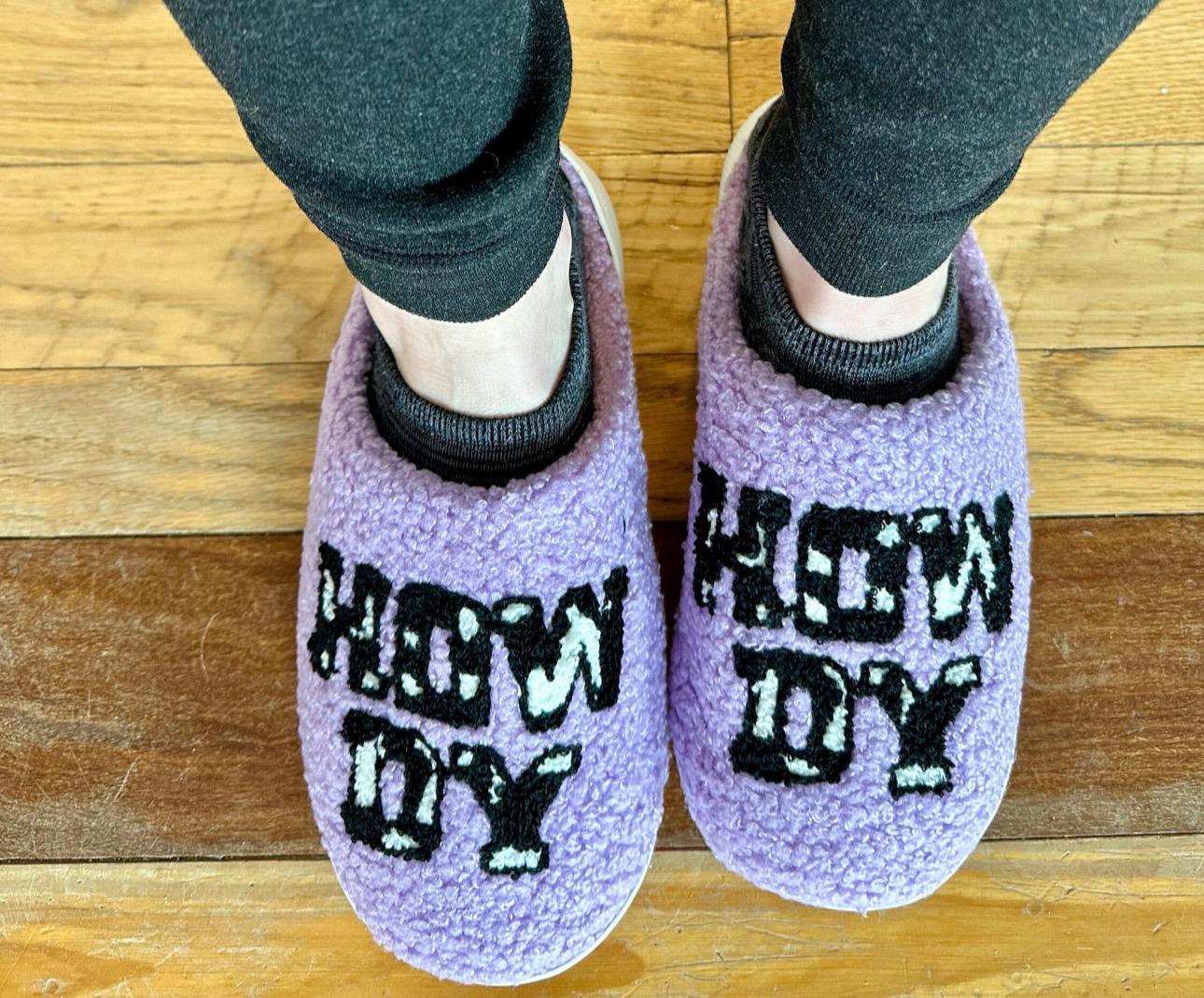 Howdy Cowgirl! The Perfect Valentine’s Gift – Introducing Purple Howdy Slippers 💖With their bold purple color, playful cowprint, and cheerful &quot;Howdy&quot; design, these slippers are the perfect blend of style and comfort. Ships FREE with $35 purchase