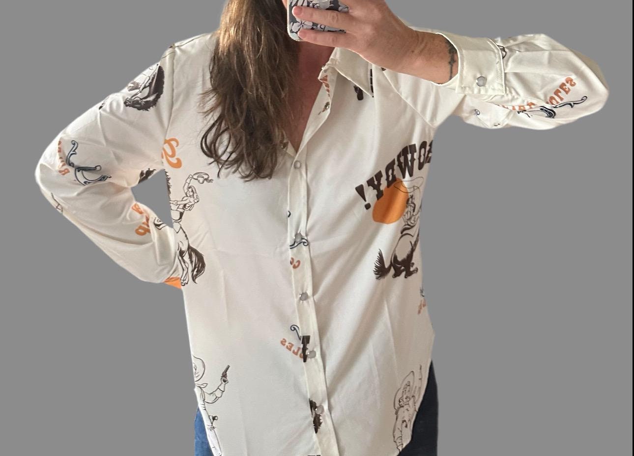 Women&#39;s off-white long-sleeved Western button-up shirt featuring &#39;Cowgirl Rules,&#39; roping cowgirls, howdy text, and horseshoes. Perfect Fall blouse for layering with jeggings and other seasonal styles