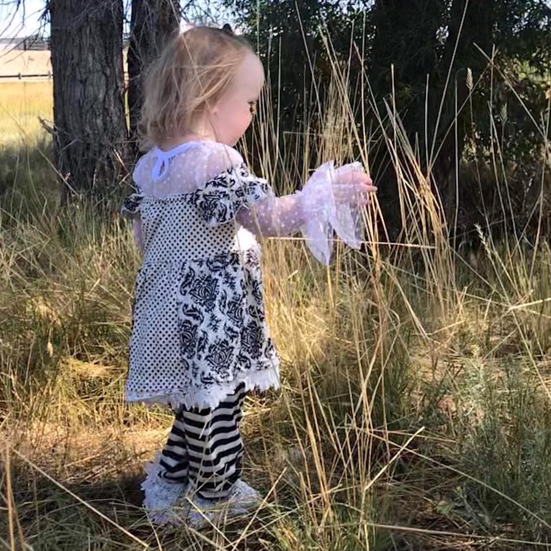 Black and White Lace Outfit – A Stunning 3-Piece Set for Little Girls. This Girls&#39; Lace Top, Tunic Tank, and Striped Pants set is a timeless and elegant choice for special occasions. Whether for a family gathering, formal event, or a more somber occasion, this outfit is as versatile as it is stylish.
3 Piece set includes lace  ruffle shirt, tunic tank and striped pants with a lace hem. This set ships FREE from Montana with $35+ purchase from RAZELS.