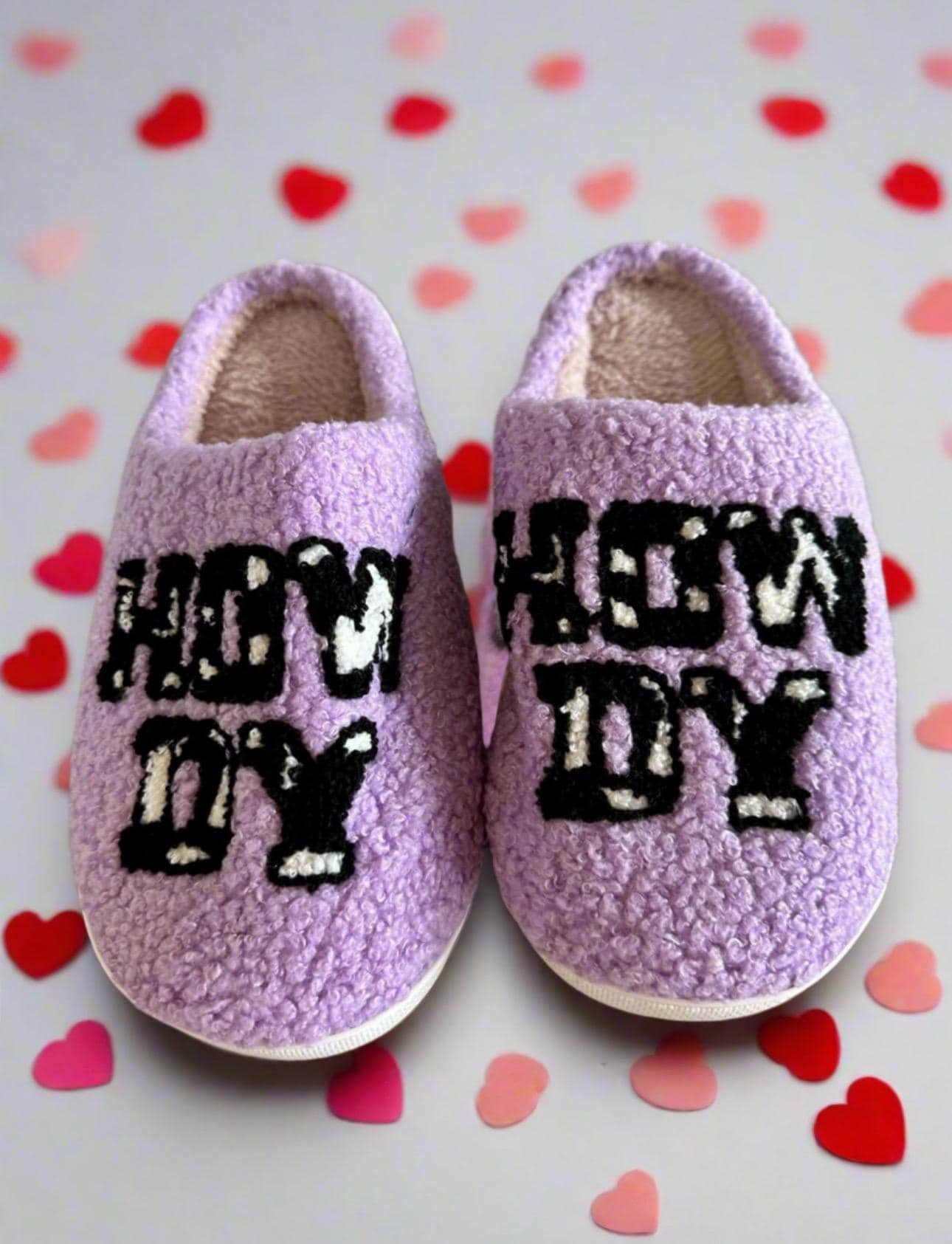 Howdy Cowgirl! The Perfect Valentine’s Gift – Introducing Purple Howdy Slippers 💖With their bold purple color, playful cowprint, and cheerful &quot;Howdy&quot; design, these slippers are the perfect blend of style and comfort. Ships FREE with $35 purchase