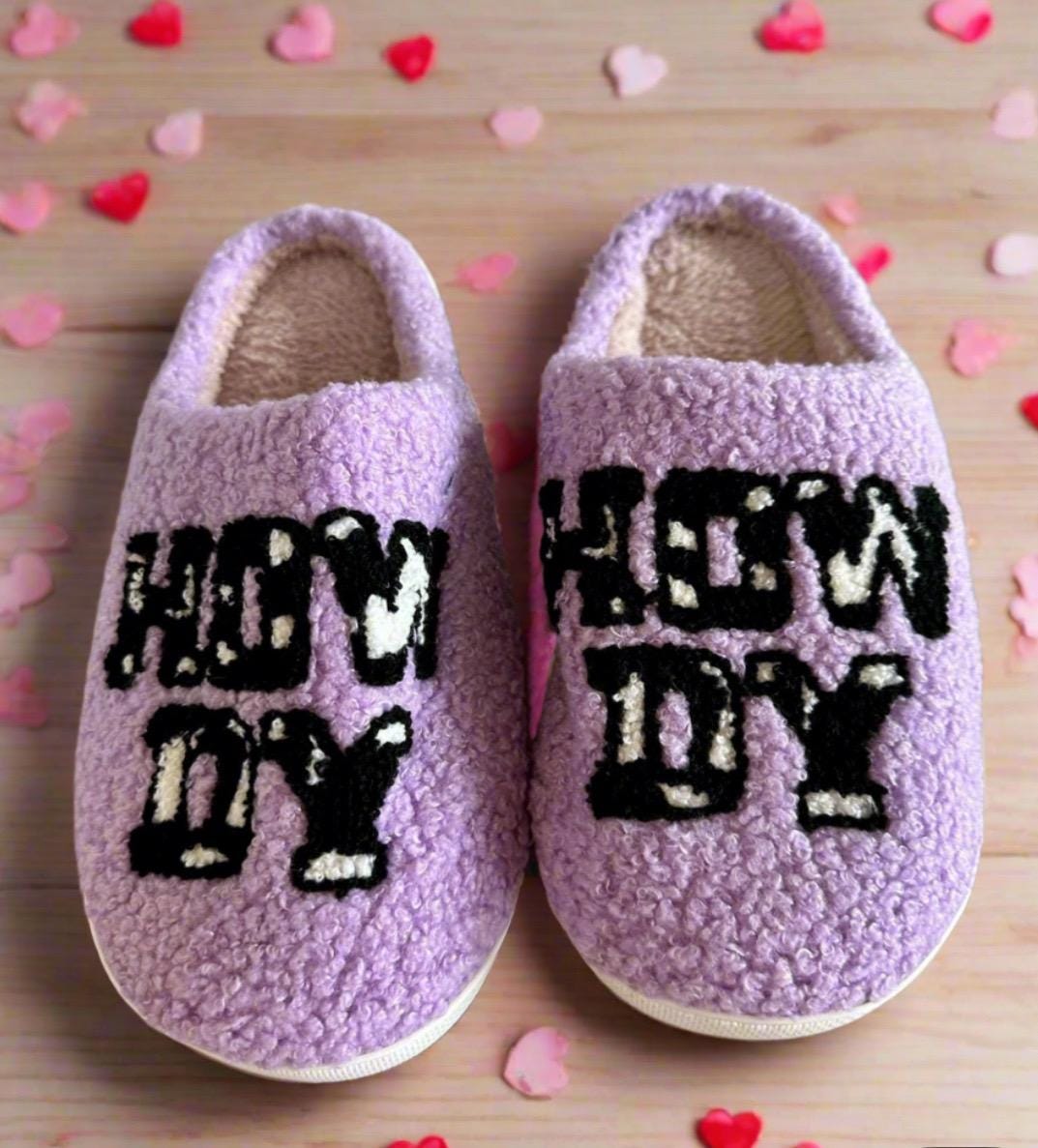 Howdy Cowgirl! The Perfect Valentine’s Gift – Introducing Purple Howdy Slippers 💖With their bold purple color, playful cowprint, and cheerful &quot;Howdy&quot; design, these slippers are the perfect blend of style and comfort. Ships FREE with $35 purchase