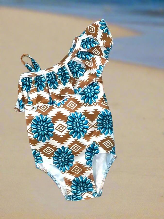 Cowgirl Swimsuit, Turquoise Conchos, Western Swimsuits, SOUTHWESTERN, Squash blossoms, Girls One piece swim, Ruffle Swimsuit, Girls&#39; Western Swimsuit  Two of our favorite things – Aztec prints and turquoise concho squash blossoms – come together in this stunning Western-inspired swimsuit! 😍 This girls&#39; one-piece ruffle swimsuit is a must-have for little cowgirls who love bold, Southwestern style. Available 0-3 months - girls 12/14. Ships FREE $35+ order from Montana.