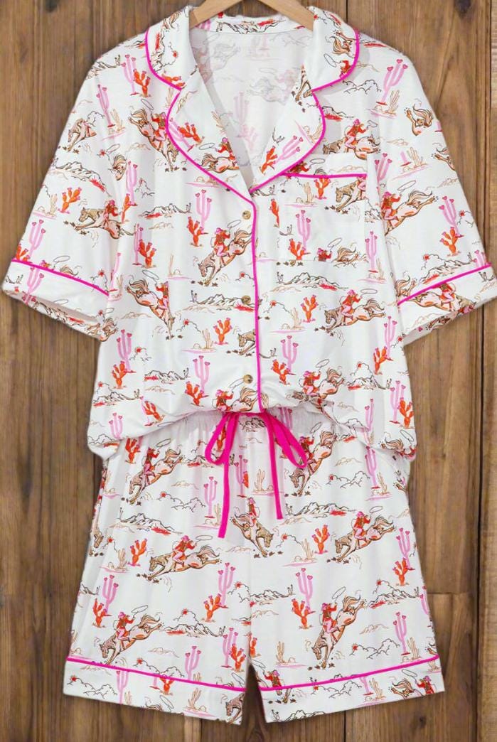 Pink Cowgirl Pajama Short Set 🩷
How fun and cowgirl-tastic is this Cowgirl Pajama Short Set?! This Western Pajama Set is the perfect blend of comfort and style, featuring a button-up top with short sleeves and matching shorts with pockets. Perfect summer cowgirl pajamas for a bridal shower or birthday gift. The playful cowgirl print showcases cowgirls doing their cowgirl thing, with hot pink piping, a drawstring, and pink and orange cacti details. SHIPS FREE from MONTANA today.