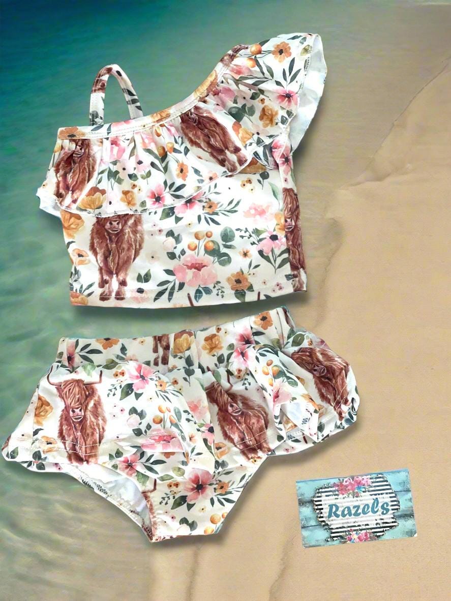 Highland Cow Swimsuit – The Sweetest Western Tankini! 🐂💖
Calling all Highland Cow lovers! This adorable Highland Cow Swimsuit features the funnest (yes, that&#39;s a word for this cuteness!) Scottish Highlander Cows and Flowers in a stylish tankini design. With a ruffled neckline and a skirted bottom, this Cowgirl Swimsuit for Kids is as sweet as it is fun! 🌸🐂

✔ Available Sizes: 0-3 months to 8/9!
