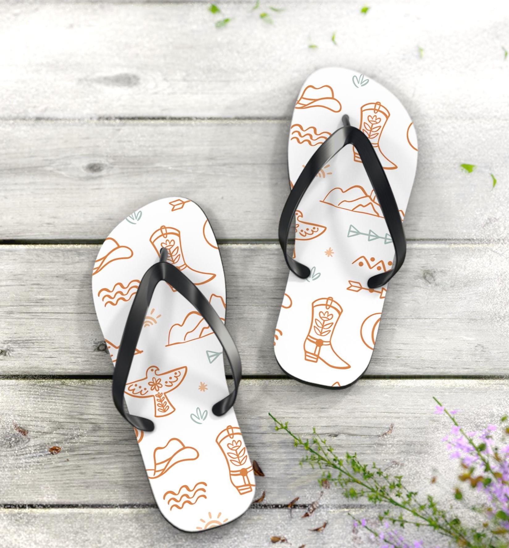 COWGIRL FLIPFLOPS, WESTERN MOTIF FLIPFLOPS, 
SUMMER COWGIRL
✓ Soft polyester suede straps that are gentle on your skin
✓ Cushy, lightweight EVA sole for all-day wear
✓ Non-slip design for poolside sips and rocky path detours
✓ Eye-catching western pattern packed with thunderbirds, arrows, boots & mountains
✓ Easygoing style perfect for lake days, rodeo nights, or porch sittin’ with sweet tea
✓ Multiple sizes so every cowgirl (and cowboy) can find their fit