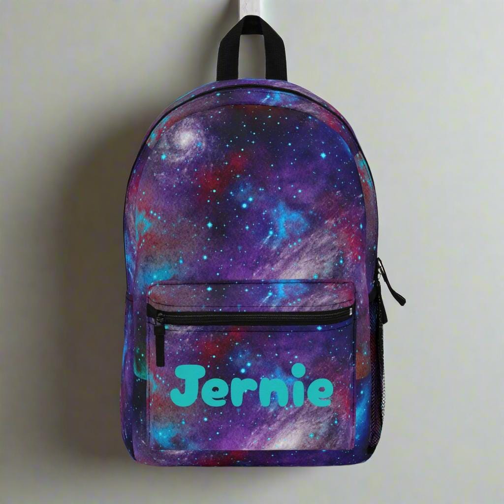 Galactic Personalized Backpack – A Universe of Style & Imagination 🌌
ships for FREE

✓ Custom name in vibrant turquoise 
✓ Mesmerizing galaxy print
✓ Spacious & practical with four compartments
✓ Comfy padded back and mesh straps
✓ Durable 100% polyester – easy to clean, quick to dry
✓ Lightweight, adjustable, and ready for lift-off