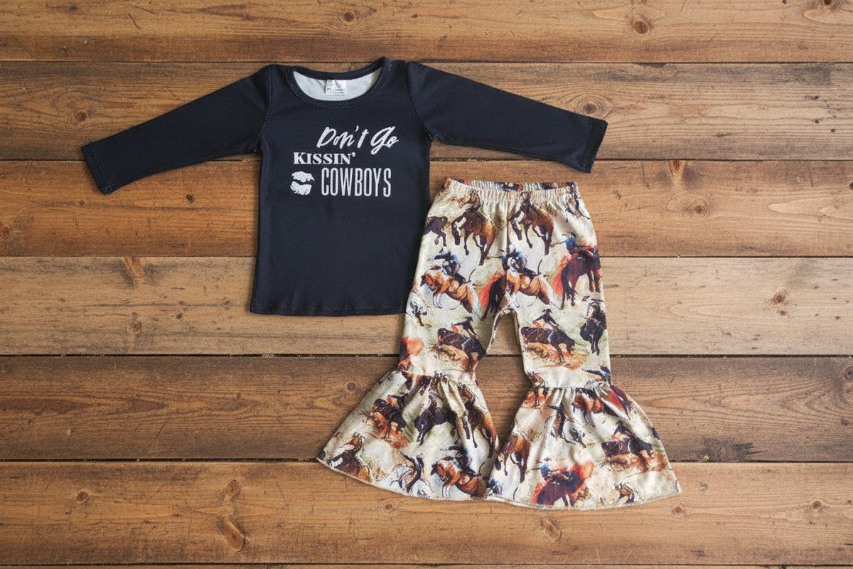 girls kissing cowboys bell bottom outfit on barnwood
