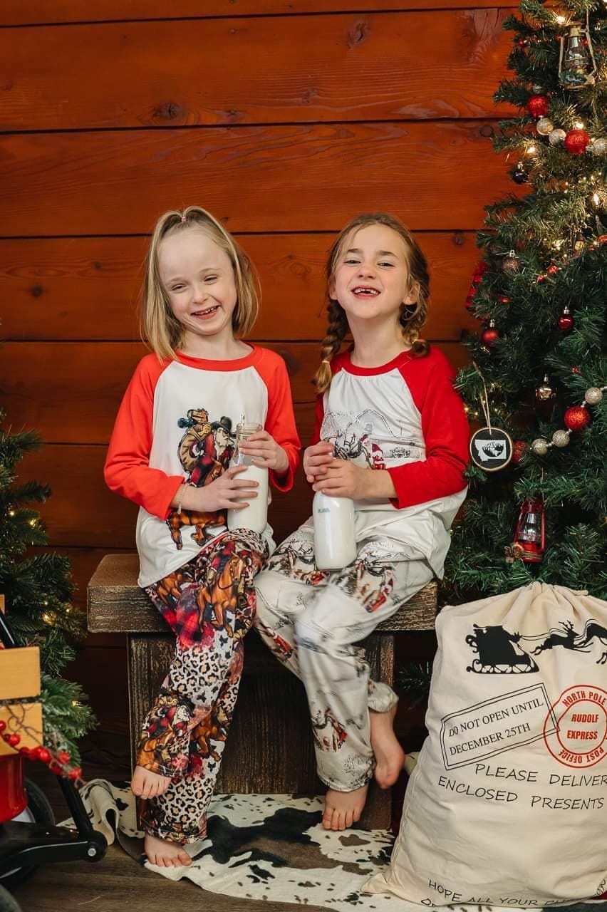 Cowboy Santa Pajamas featuring Santa riding his best horse in a collage of cheetah print, buffalo plaid and Cowboy Christmas spirit! PJ set in 3/6 months baby through adult 3x! Pajamas for EVERYONE!