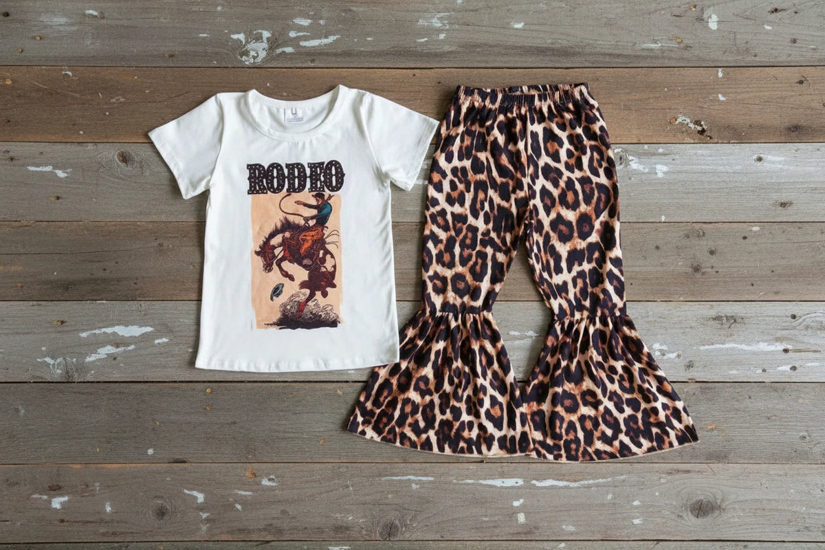 razels rodeo cheetah tshirt and cheetah print bell bottom pants on a barnwood background