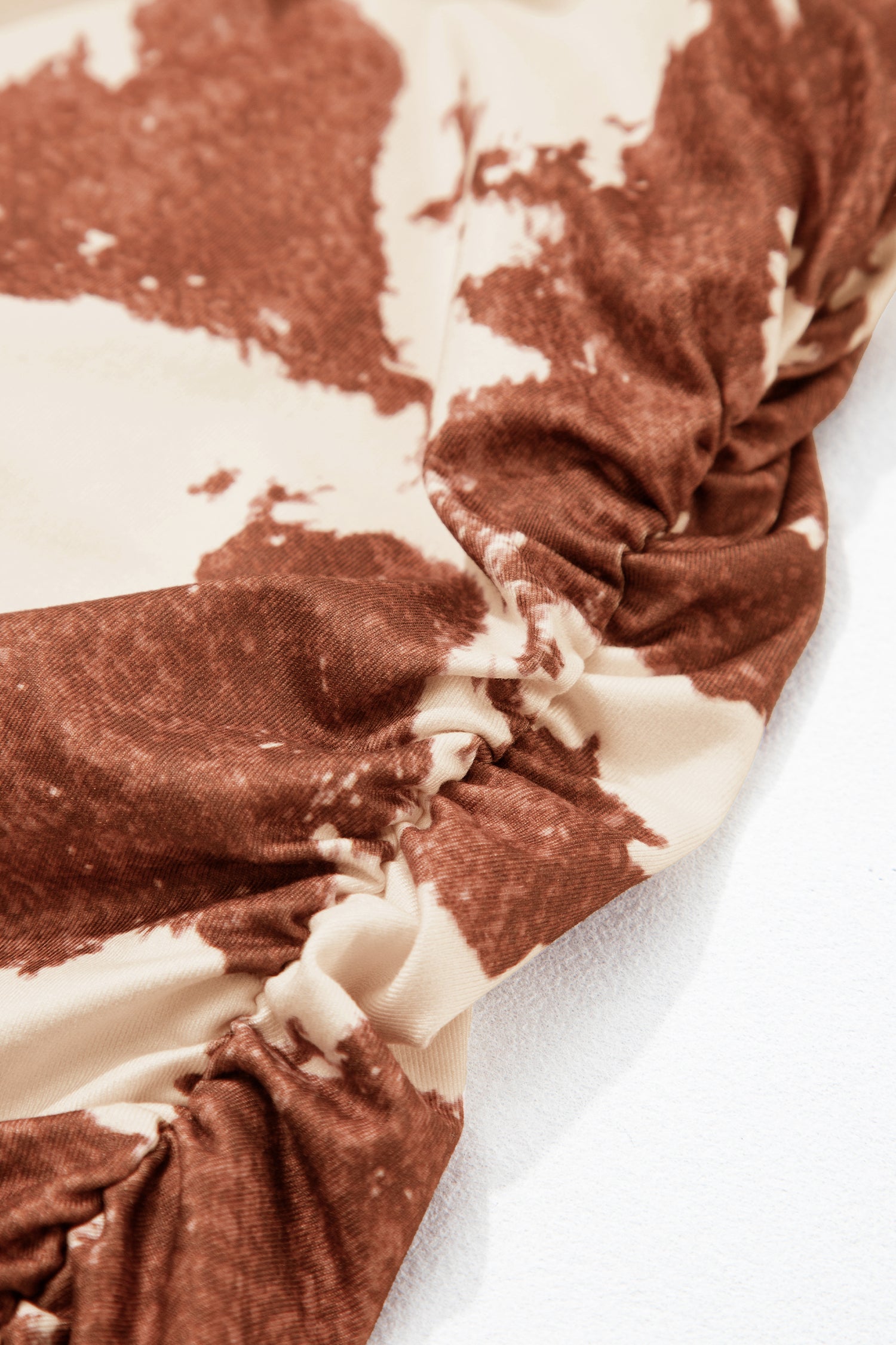 A close-up of a ruched side of cowhide shirt for women against white background