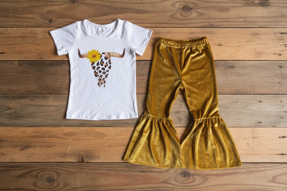 girls sunflower cow tshirt and golden velvet bell bottoms against a barnwood background