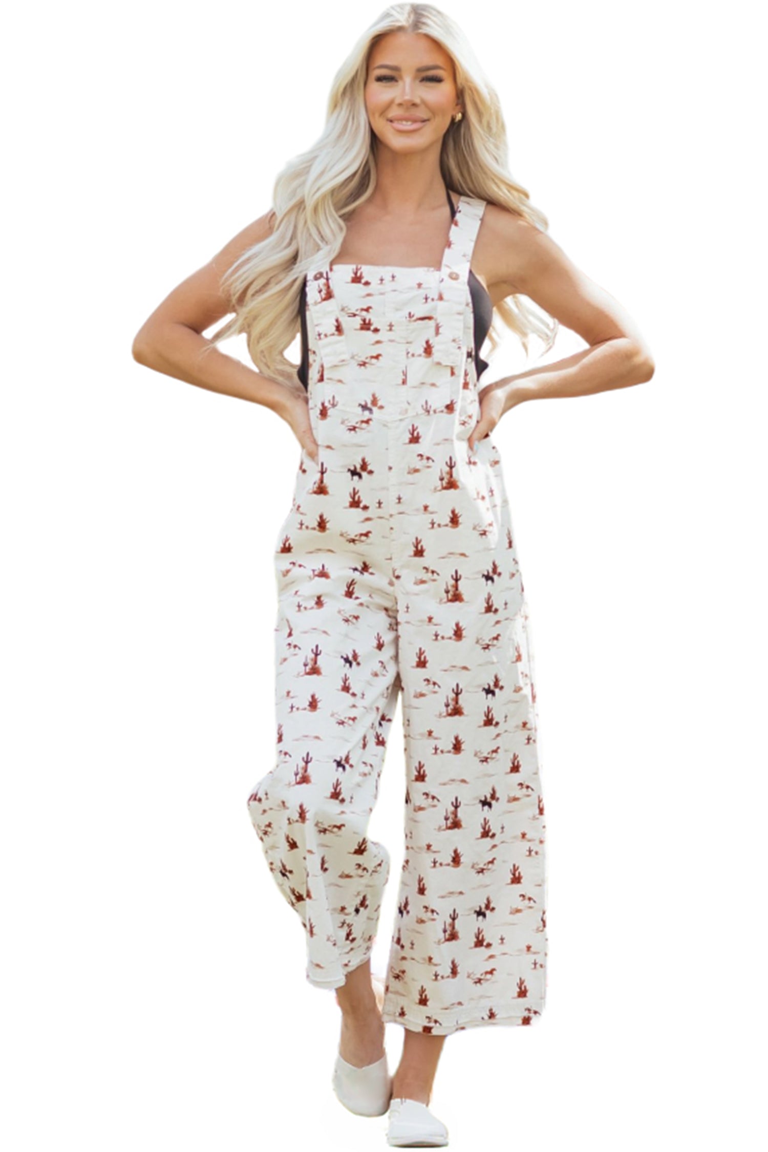 Woman wearing a white overalls with desert cowboy scene patterns on a white background