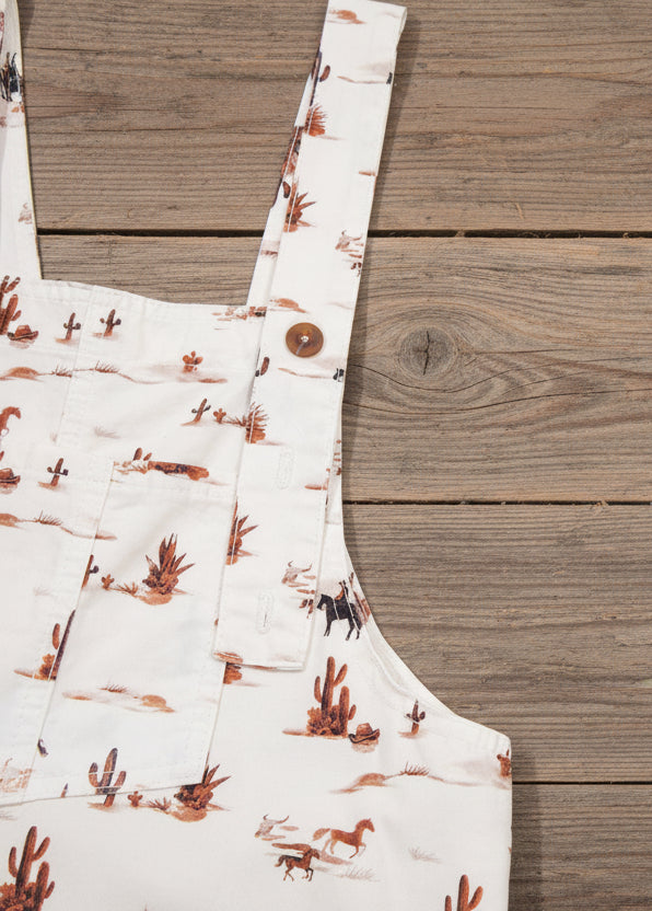 womens western jumpsuit with desert landscape print on a beige background